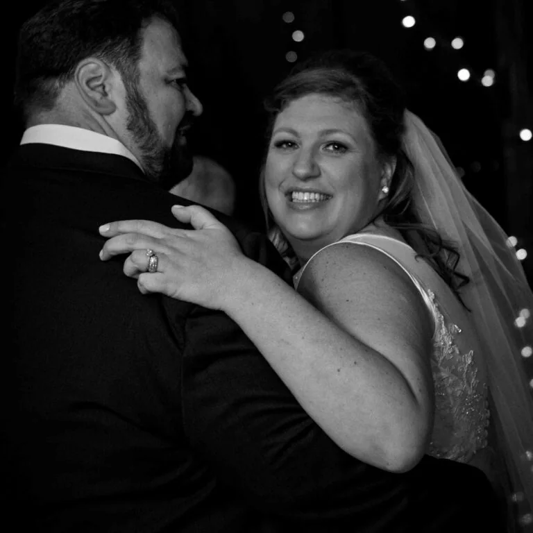 Erica LaFerlita, founder of The Savvy Bride, smiling over her shoulder while dancing with her husband on her wedding day